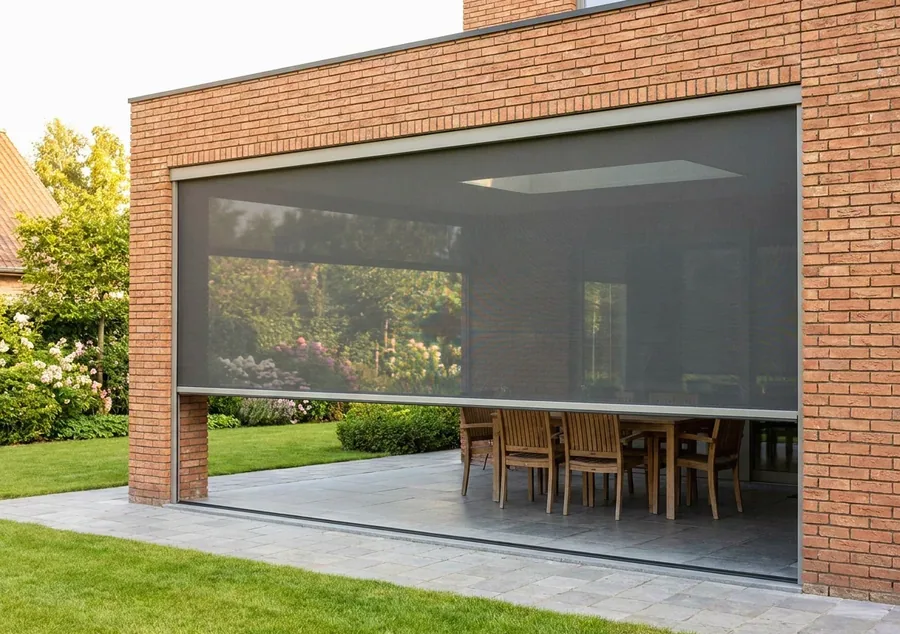 Zip screen mesh drawn down the open side of a covered patio, held taut in its side channels